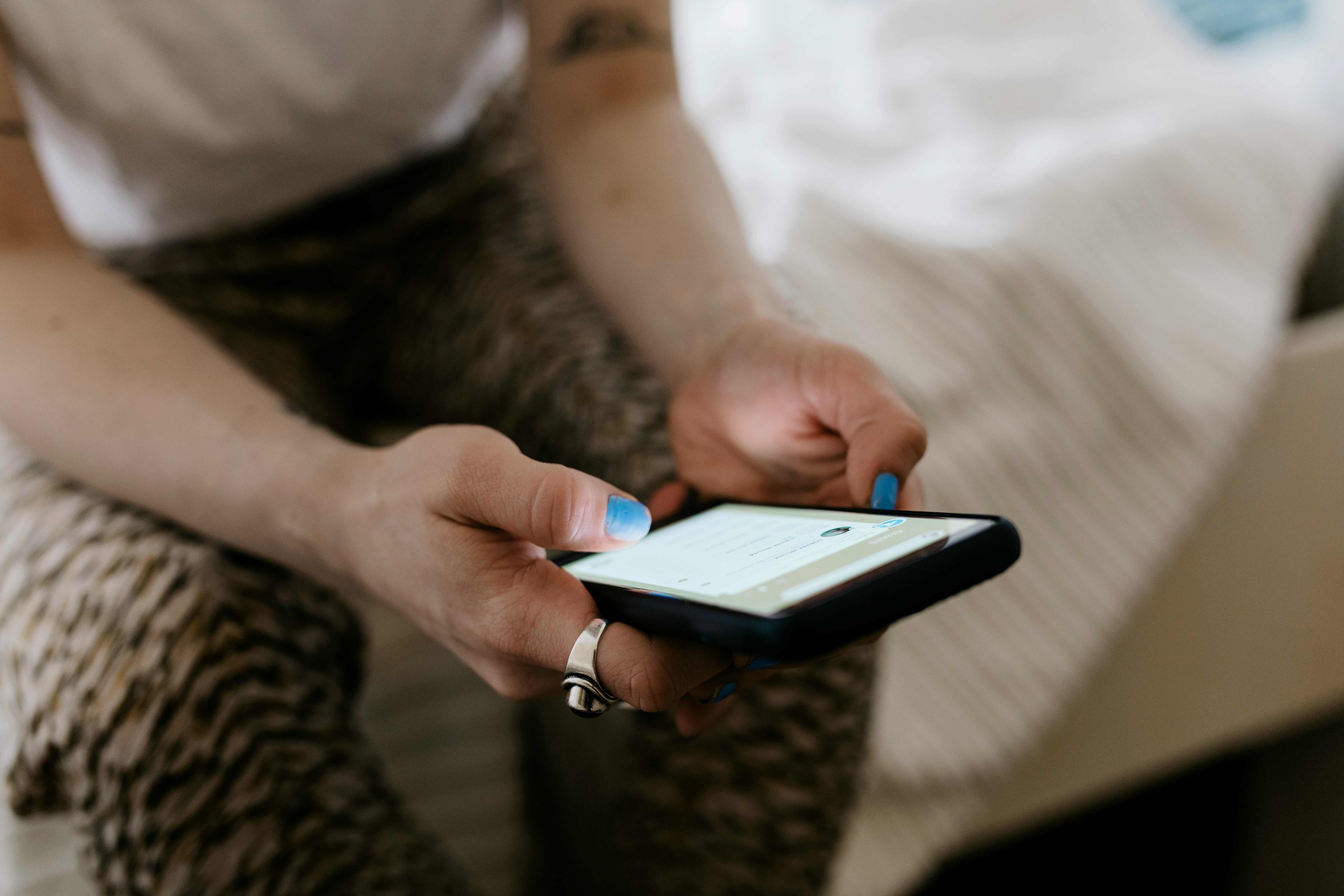 A woman scrolls on TikTok at home. TikTok updated its community guidelines to ban deadnaming and oth...