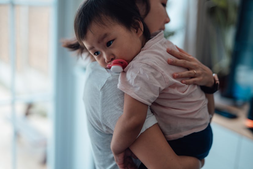 Cropped shot of young Asian mother embracing and comforting her daughter at home. Family bonding. To...