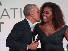 CHICAGO, ILLINOIS - OCTOBER 29: Former U.S. President Barack Obama gives his wife Michelle a kiss as...