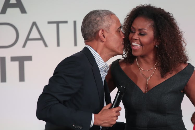 CHICAGO, ILLINOIS - OCTOBER 29: Former U.S. President Barack Obama gives his wife Michelle a kiss as...