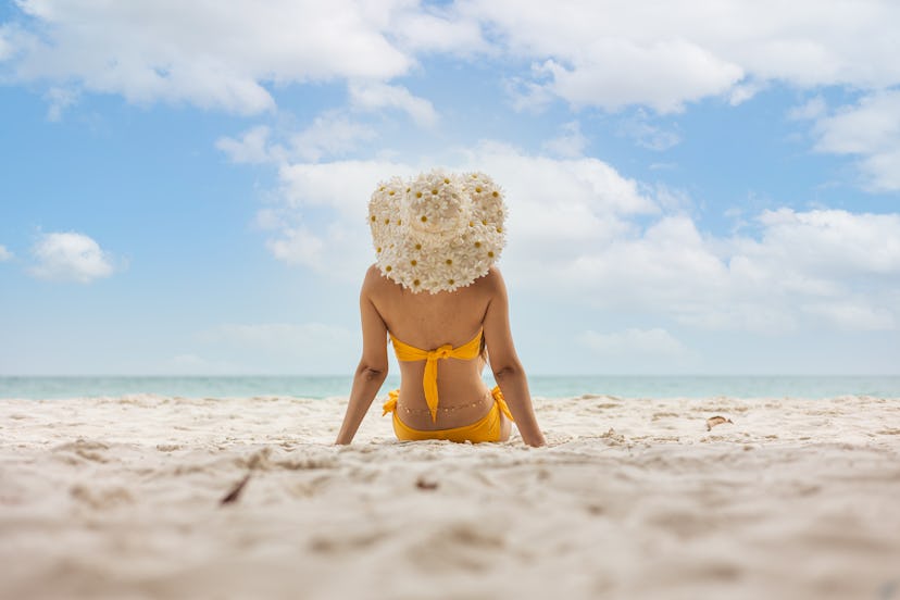 Young woman in bikini sitting at beach