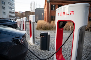 22 January 2022, Berlin: Tesla brand vehicles are parked at a series of Tesla fast-charging stations...