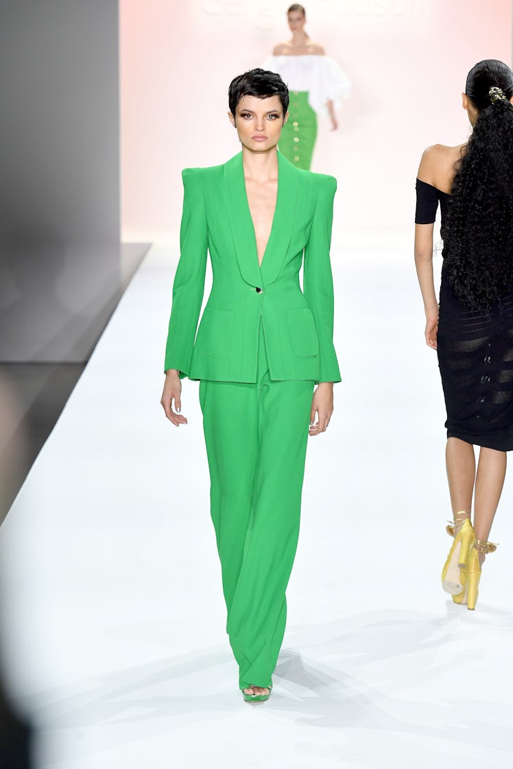 A model walking the runway in a green suit by Sergio Hudson during New York Fashion Week Spring 2022