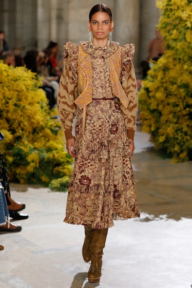 Model on the NY Fashion Week Fall 2022 runway in Ulla Johnson yellow and brown dress with flower det...