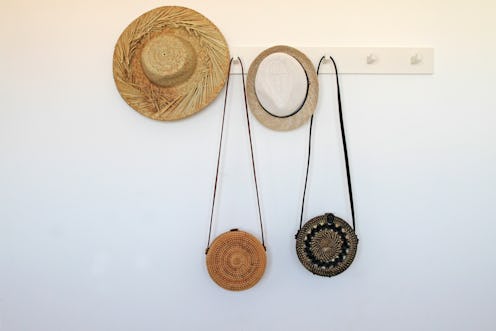 Straw hats and hand bags hanging on rack