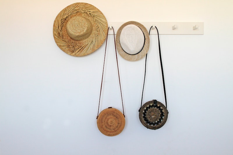 Straw hats and hand bags hanging on rack