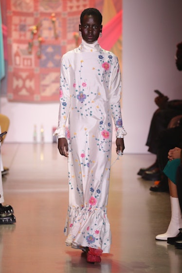 Model on the NY Fashion Week Fall 2022 runway in House of Aama white silk turtleneck dress with flow...