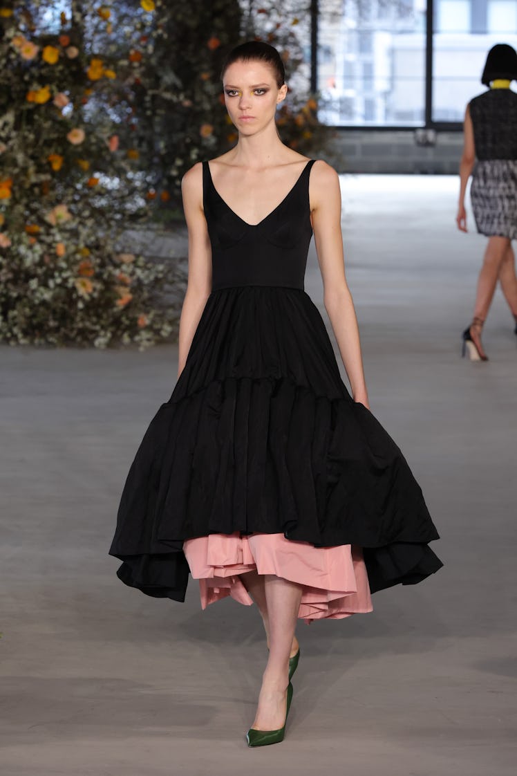 Model on the NY Fashion Week Fall 2022 in Jason Wu black and pink dress and green heels.