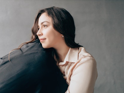 Portrait of young beautiful woman embracing pillow.