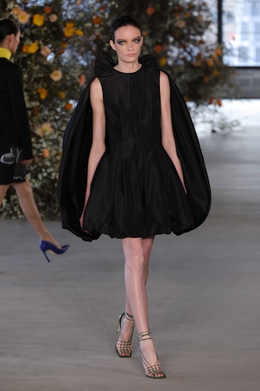Model on the NY Fashion Week Fall 2022 in Jason Wu black dress with a huge bowtie on the back and gr...