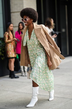 a floral print midi dress with a trench coat and white boots