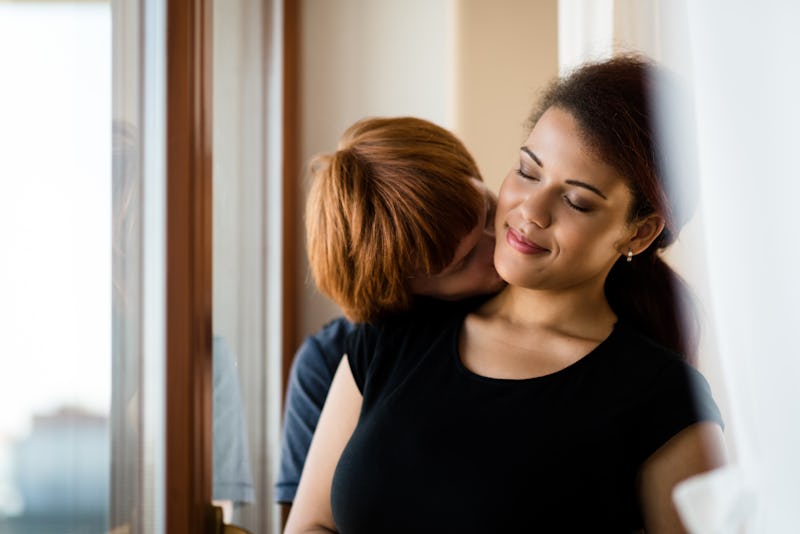 Passionate young guy kissing his girlfriend on neck