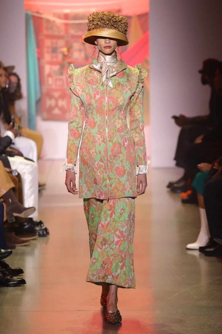 Model on the NY Fashion Week Fall 2022 runway in House of Aama floral jacket and pants with a silk s...