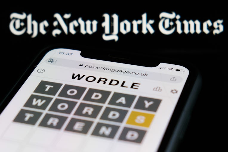 Wordle game displayed on a phone screen and The New York Times logo displayed in the background are ...
