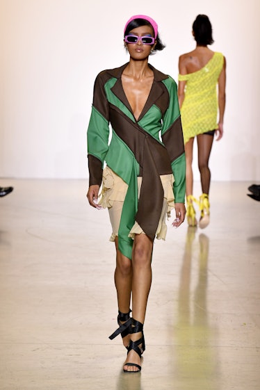 Model on the NY Fashion Week Fall 2022 runway in Kim Shui green and brow blouse with a beige skirt a...