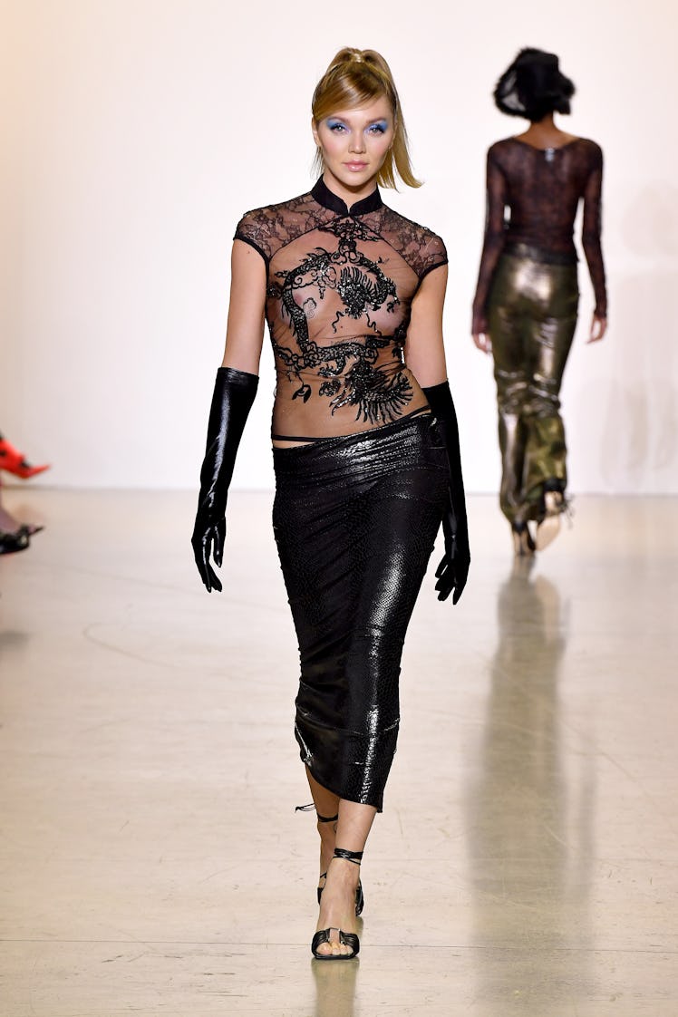 Model on the NY Fashion Week Fall 2022 runway in Kim Shui black see-through blouse with black leathe...