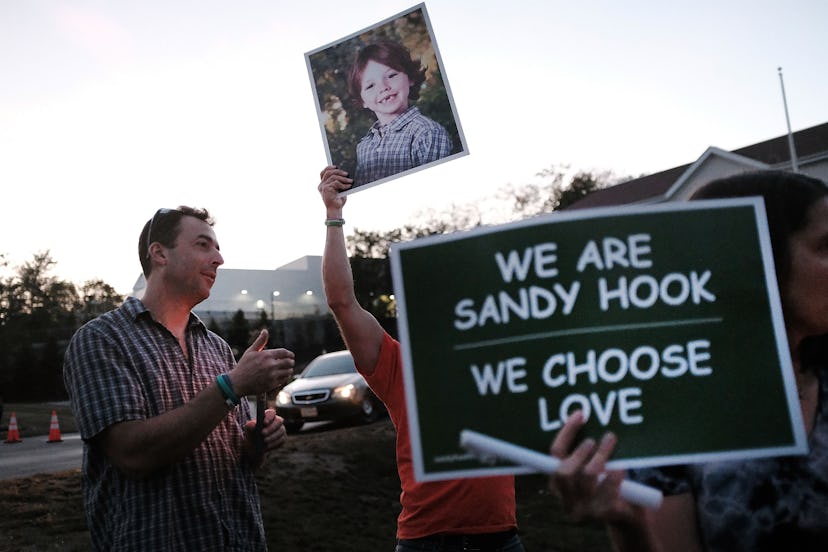 NEWTOWN, CT - OCTOBER 04:  Mark Barden holds up a picture of his son Daniel who was killed in the Sa...