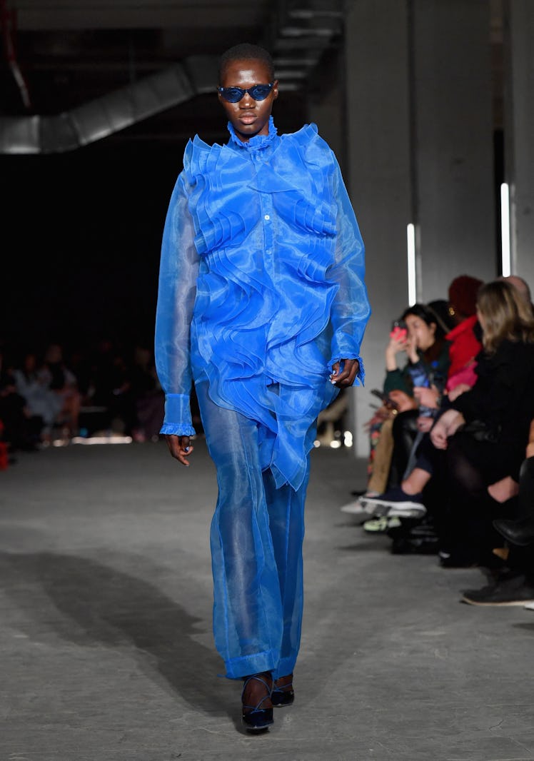 Model on the NY Fashion Week Fall 2022 runway in Christian Siriano blue almost see-through top and p...