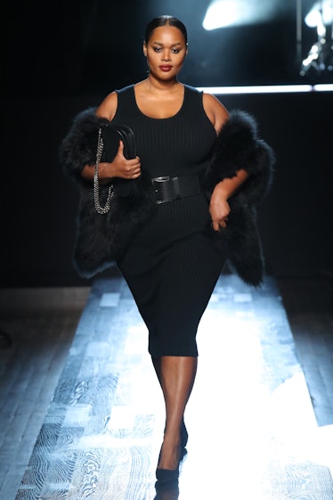 Model on the NY Fashion Week Fall 2022 runway in a Michael Kors black dress and black fur coat
