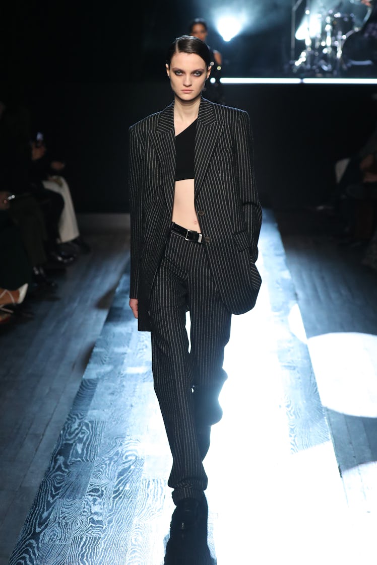 Model on the NY Fashion Week Fall 2022 runway in a Michael Kors black suit with white stripes
