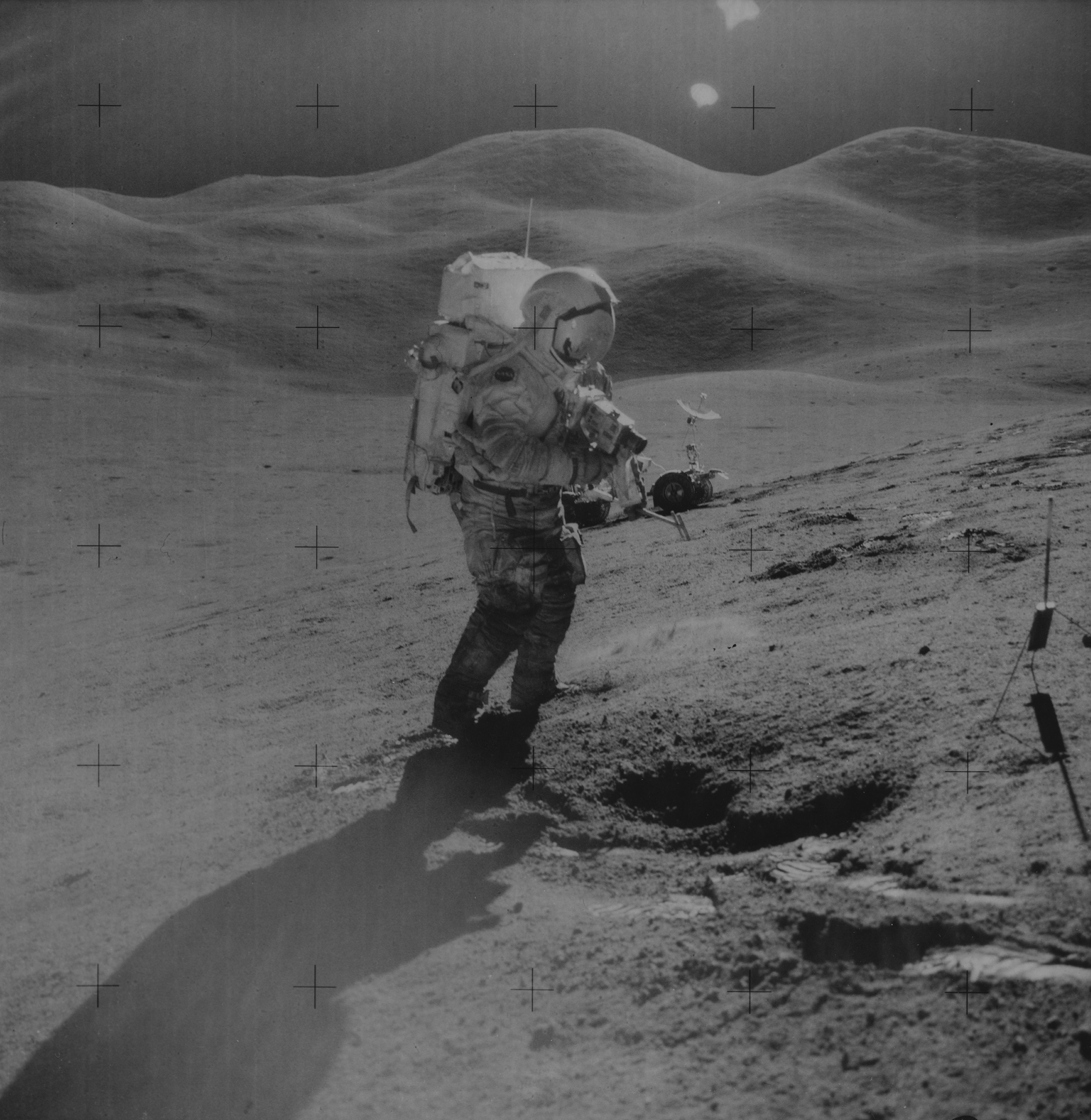 Mission Commander David R. Scott uses a 70mm camera on the Hadley Delta during the Apollo 15 lunar l...