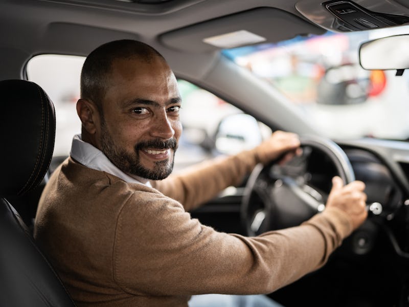 Portrait of a mature man choosing new car in car dealership