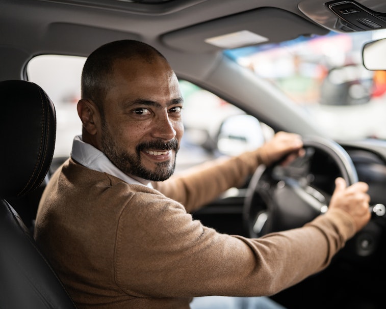 Portrait of a mature man choosing new car in car dealership