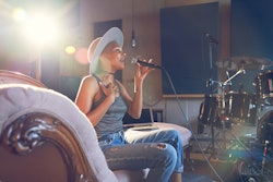 Young female musician in hat practicing. The best career for pisces zodiac signs, according to an as...