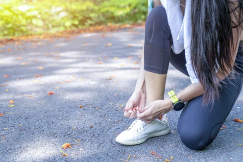 Running shoes - closeup of woman tying shoe laces. Female sport fitness runner getting ready for jog...