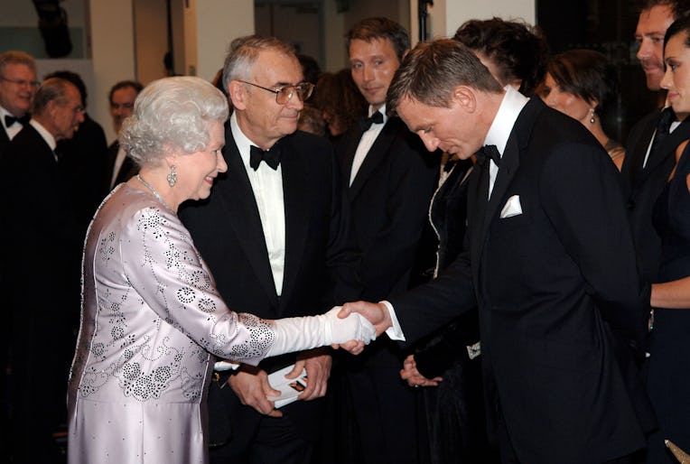 Queen Elizabeth II meets actor Daniel Craig,bowing in respect for protocol, at the premiere of the 2...