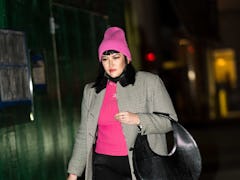 A woman wears a pink ribbed wool hat after learning how to style a beanie.