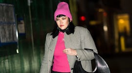 A woman wears a pink ribbed wool hat after learning how to style a beanie.