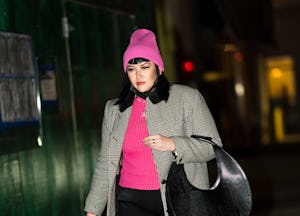 A woman wears a pink ribbed wool hat after learning how to style a beanie.