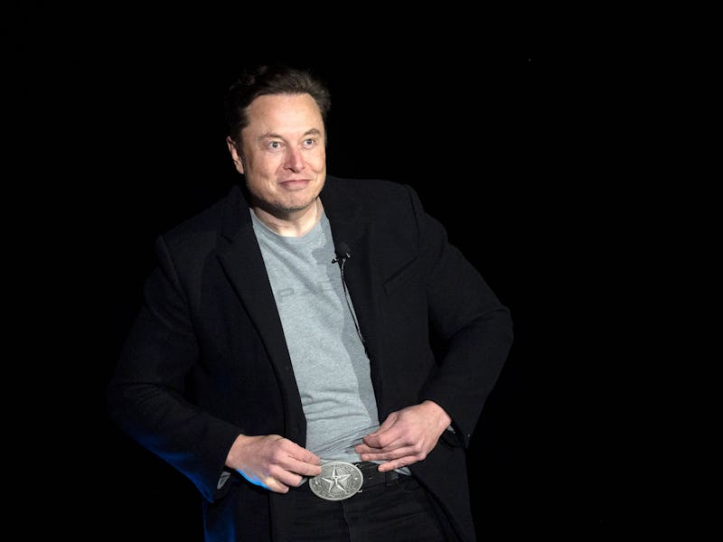 Elon Musk shows his Texas belt buckle as he speaks during a press conference at SpaceX's Starbase fa...