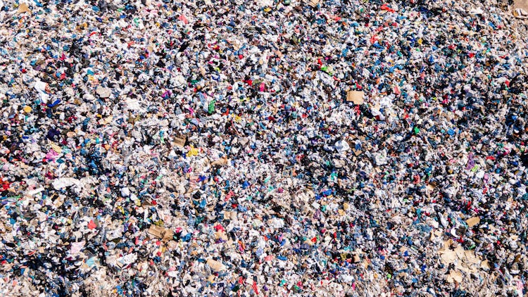 25 November 2021, Chile, Alto Hospicio: Used clothes sit in a landfill in the desert. In the nearby ...