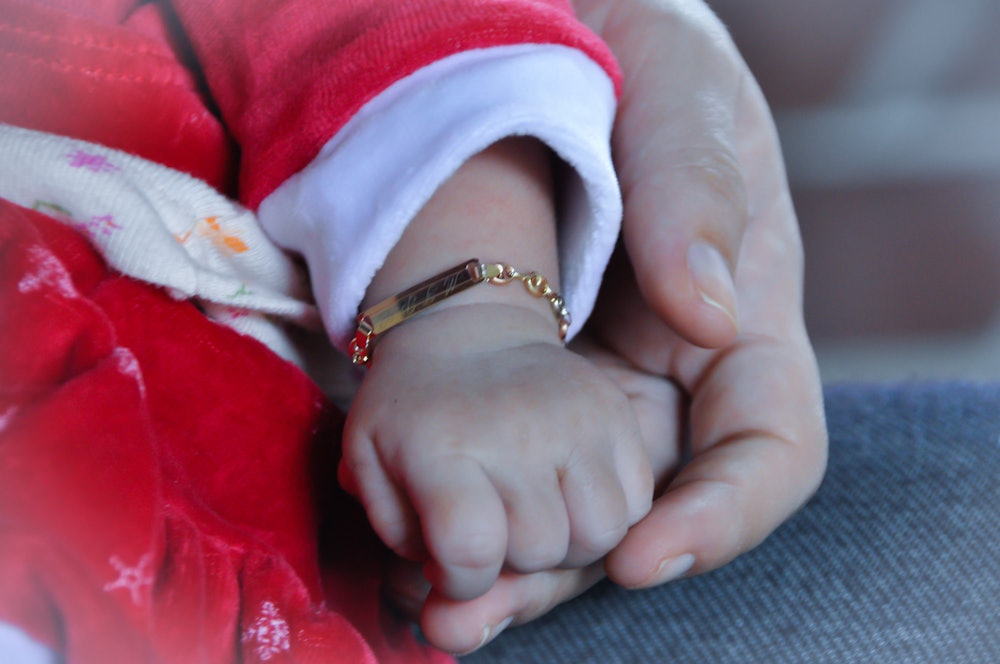 Cropped Image Of Mother Holding Baby Hand, Close-Up