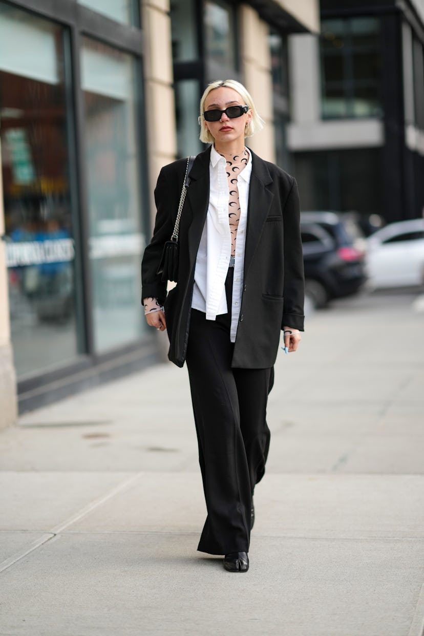 NEW YORK, NEW YORK - FEBRUARY 12: A guest wears black sunglasses from Prada, a silver piercing, silv...