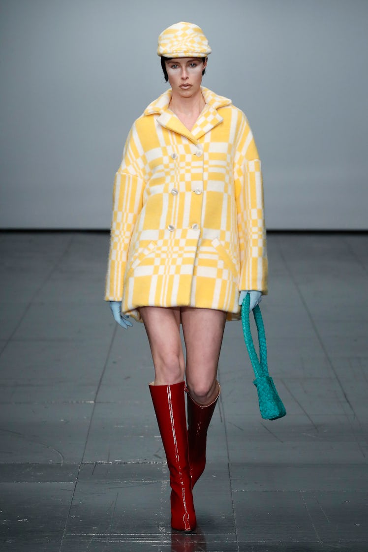 Coco Rocha in a yellow-white coat and cap and brown boots by Conner Ives 