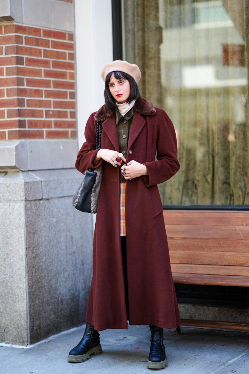 NEW YORK, NEW YORK - FEBRUARY 11: A guest wears a beige felt / wool beret, a white ribbed wool turtl...