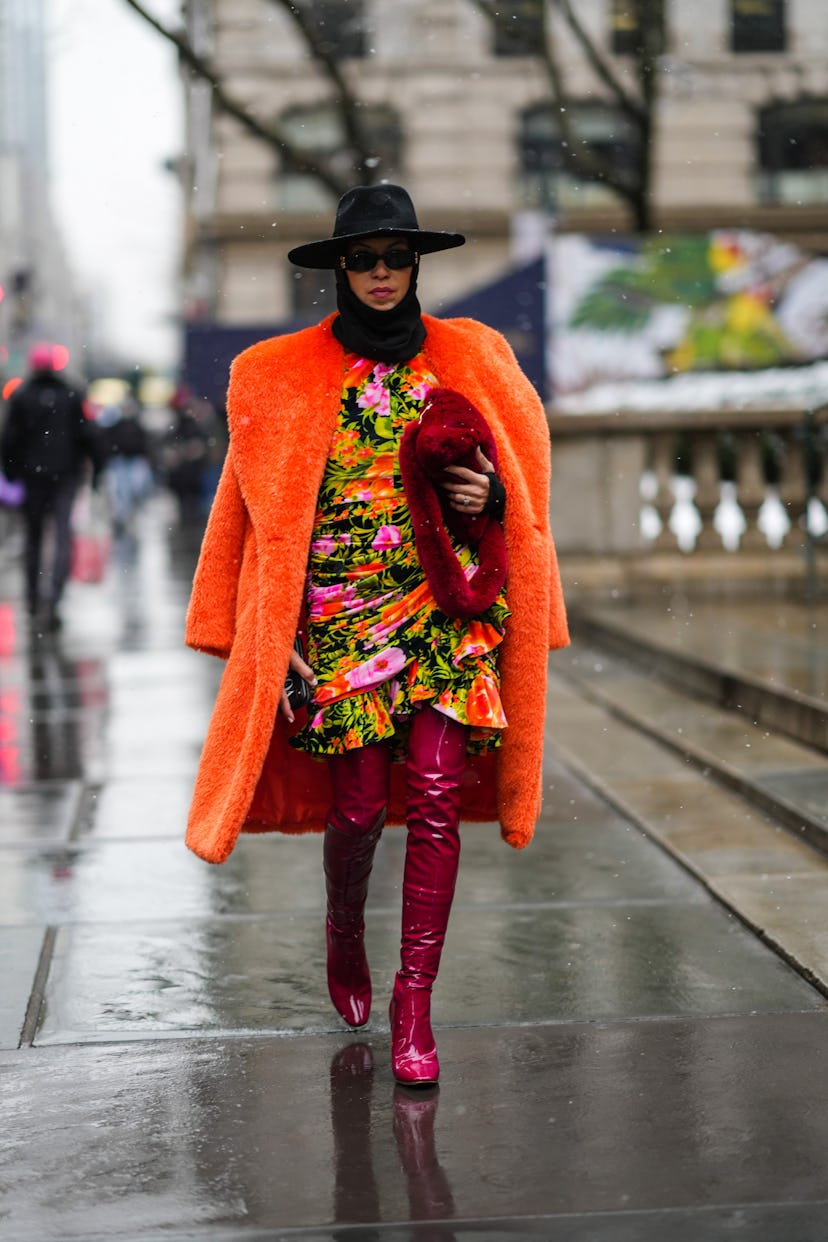 NEW YORK, NEW YORK - FEBRUARY 13: A guest wears a black felt hat, black sunglasses from Balenciaga, ...