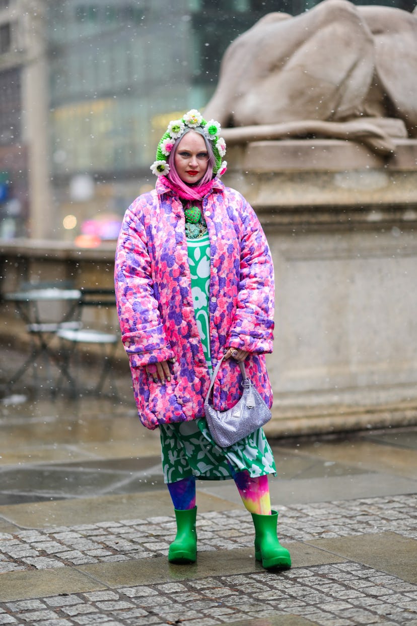 NEW YORK, NEW YORK - FEBRUARY 13: A guest wears a green wool with large embroidered white and pink d...