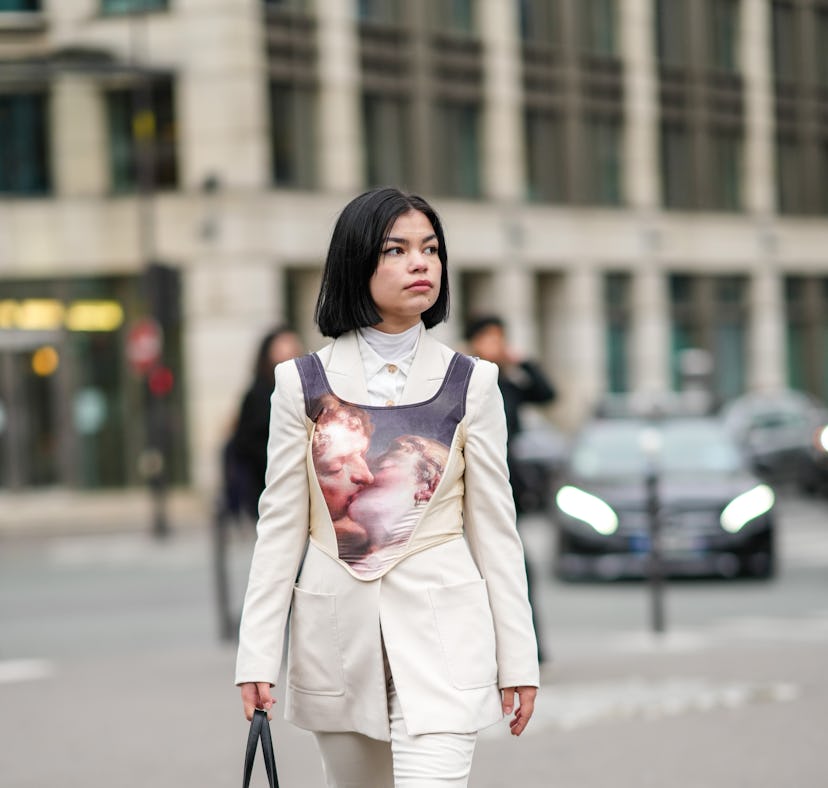 PARIS, FRANCE - JANUARY 27: A guest wears a white turtleneck pullover, a white shirt, a white latte ...