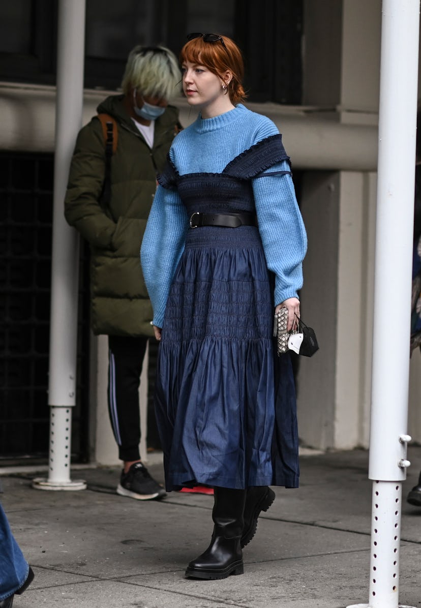 NEW YORK, NEW YORK - FEBRUARY 16: A guest is seen wearing a light blue sweater, blue dress and black...