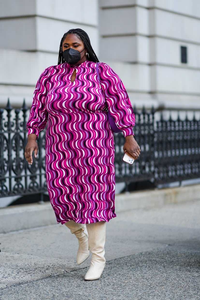 NEW YORK, NEW YORK - FEBRUARY 12: A guest wears a purple / pink / white / black wavy print pattern m...