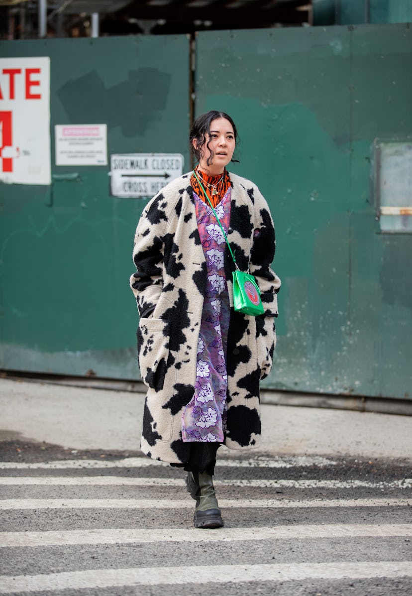 NEW YORK, NEW YORK - FEBRUARY 16: A guest is seen wearing  coat with cow animal print, sheer purple ...