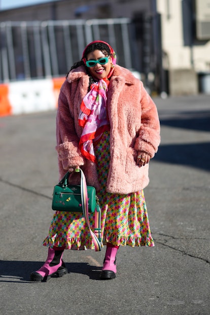 NEW YORK, NEW YORK - FEBRUARY 14: A guest wears dark green sunglasses, a red / pink / green flower p...