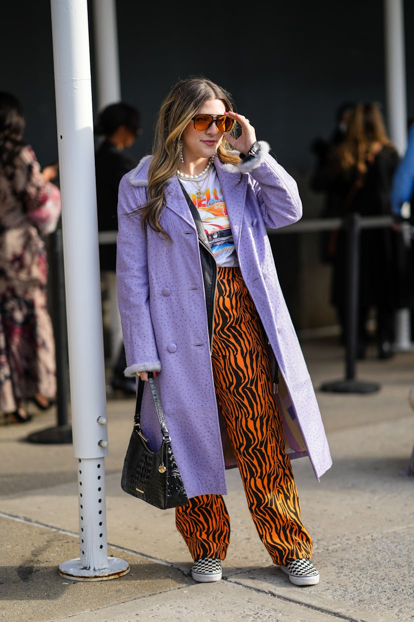 NEW YORK, NEW YORK - FEBRUARY 12: A guest wears orange sunglasses, silver and rhinestones fringed ea...