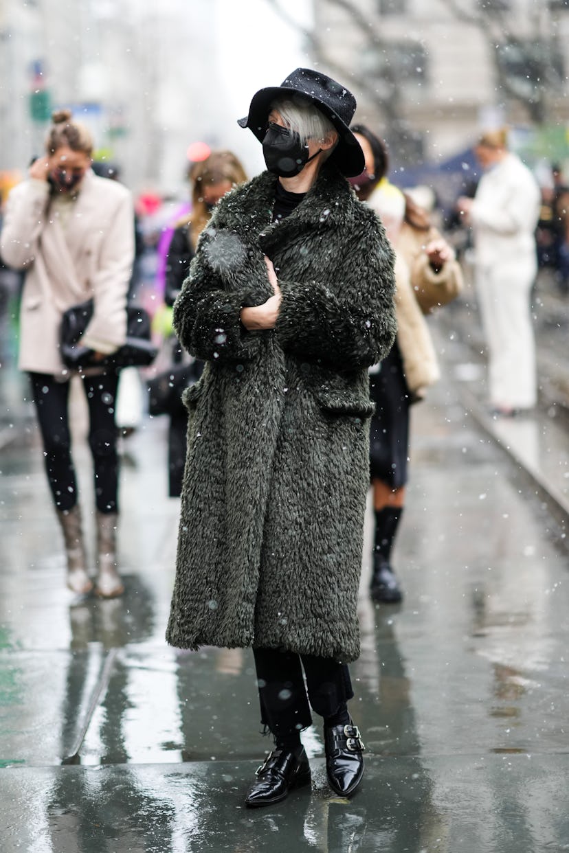 NEW YORK, NEW YORK - FEBRUARY 13: A guest wears a black large bob har, a black high neck pullover, a...