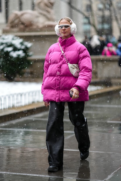 NEW YORK, NEW YORK - FEBRUARY 13: A guest wears  pale pink hair clip, a white fluffy ear muffs, a pi...