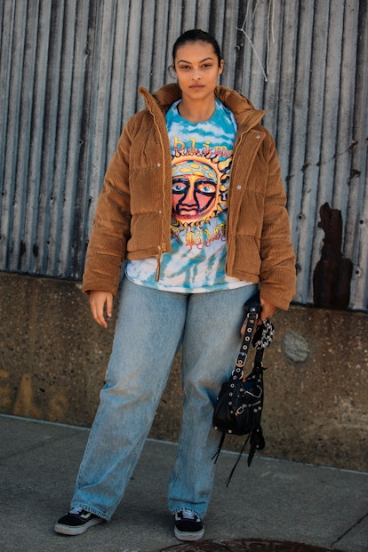 NEW YORK, NEW YORK - FEBRUARY 15: Model Devyn Garcia wears a brown cropped corduroy jacket, blue tie...